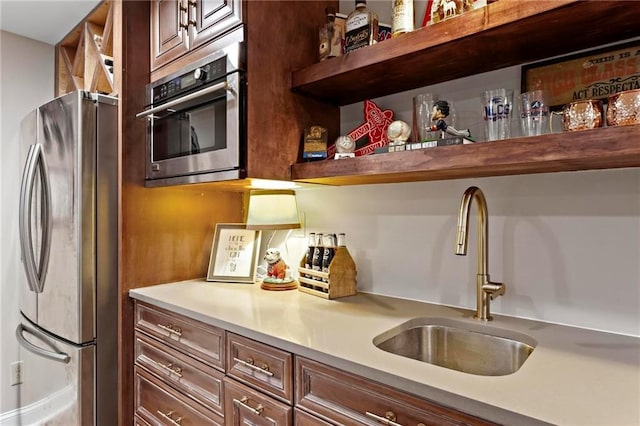 kitchen featuring sink, stainless steel appliances, and dark brown cabinetry