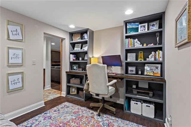 office featuring built in shelves and dark hardwood / wood-style floors