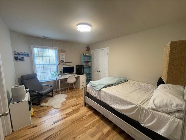 bedroom with a closet, visible vents, and light wood-type flooring