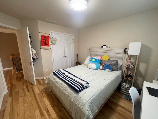 bedroom featuring visible vents, light wood-style floors, a closet, and baseboards