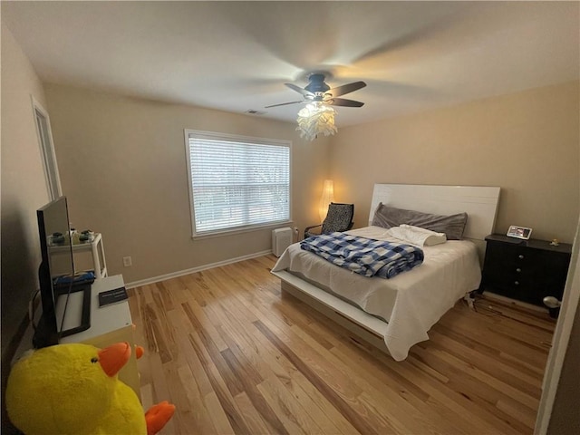 bedroom with visible vents, baseboards, light wood-style floors, and a ceiling fan