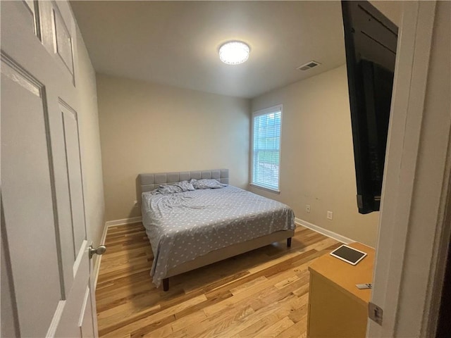 bedroom featuring light wood-type flooring, baseboards, and visible vents