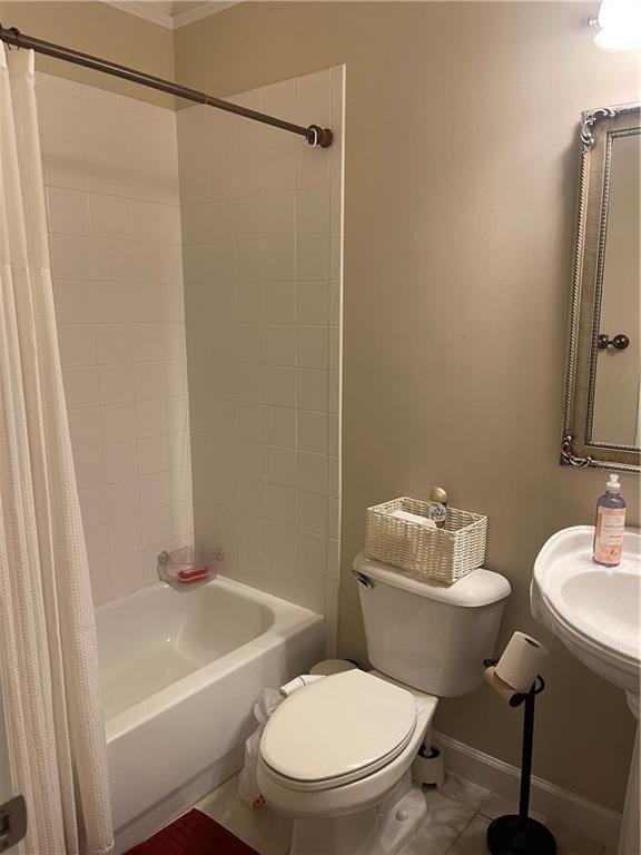 full bath featuring tile patterned flooring, baseboards, toilet, shower / bath combo with shower curtain, and a sink