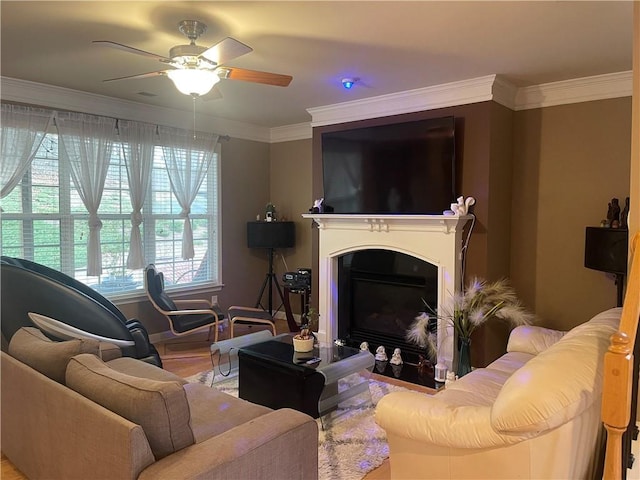 living room featuring a glass covered fireplace, wood finished floors, ceiling fan, and ornamental molding