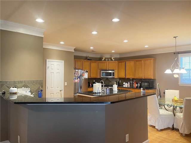 kitchen featuring pendant lighting, ornamental molding, brown cabinetry, and stainless steel appliances