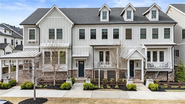 townhome / multi-family property with fence, brick siding, board and batten siding, roof with shingles, and french doors
