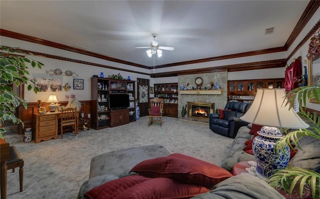 carpeted living area with a fireplace, ceiling fan, visible vents, and crown molding