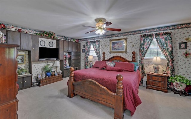 carpeted bedroom with wallpapered walls and a ceiling fan