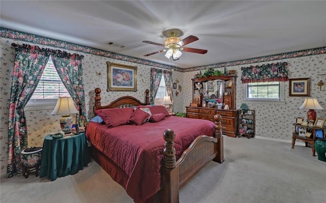 carpeted bedroom featuring wallpapered walls, baseboards, ceiling fan, and visible vents