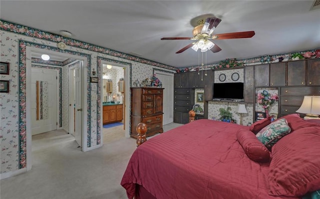 bedroom with wallpapered walls, connected bathroom, visible vents, light carpet, and ceiling fan