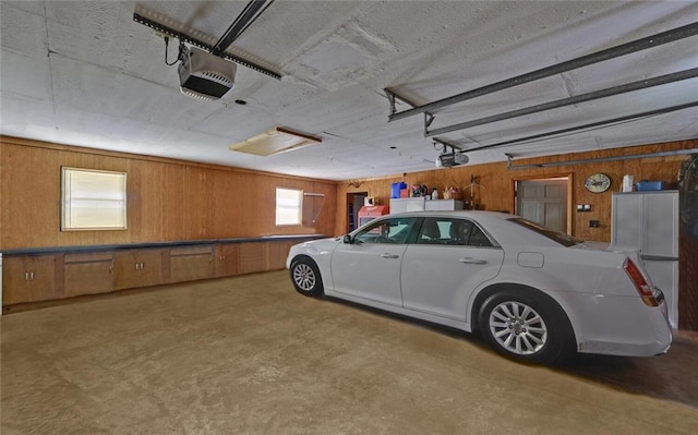 garage with wood walls and a garage door opener