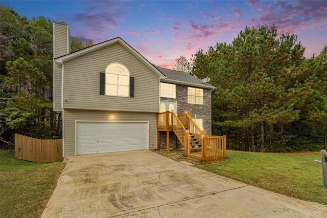 bi-level home featuring a lawn and a garage