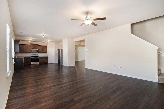 kitchen featuring stainless steel appliances, dark hardwood / wood-style floors, decorative light fixtures, and ceiling fan with notable chandelier