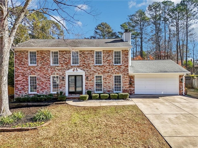 colonial inspired home featuring a front yard and a garage