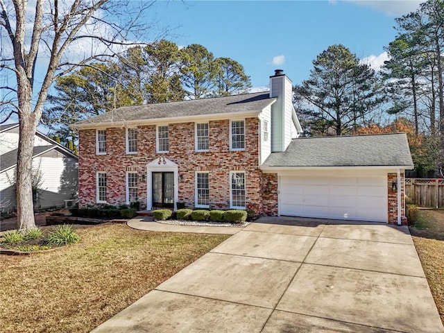 colonial house featuring a garage and a front yard