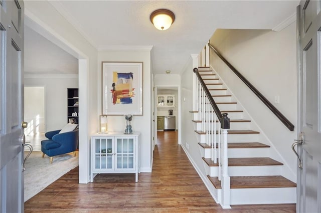 foyer entrance featuring dark wood-type flooring and ornamental molding