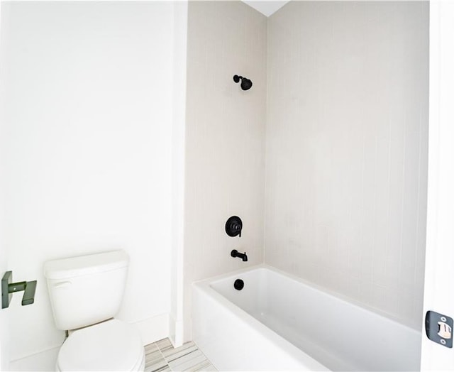 bathroom featuring tiled shower / bath and toilet