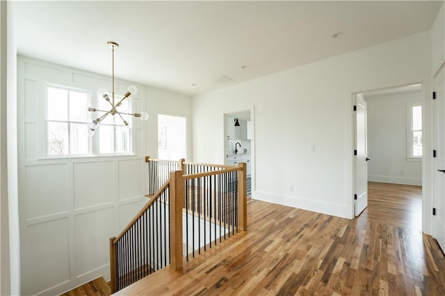 hall featuring hardwood / wood-style flooring, sink, and a notable chandelier