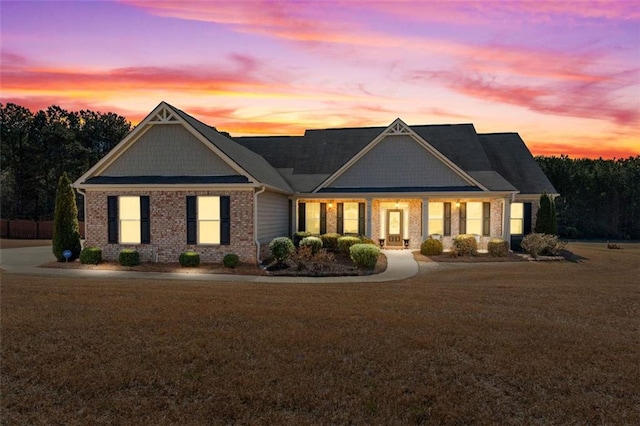 craftsman house with brick siding and a lawn