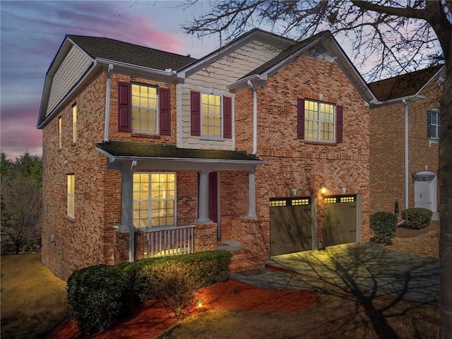 view of front of home featuring a garage, brick siding, driveway, and a porch