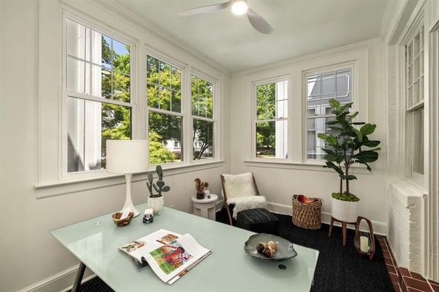 sunroom / solarium featuring plenty of natural light and a ceiling fan