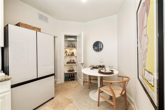 dining area featuring light tile patterned floors, baseboards, and visible vents