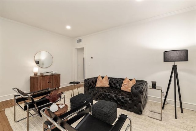 living area featuring baseboards, wood finished floors, visible vents, and ornamental molding