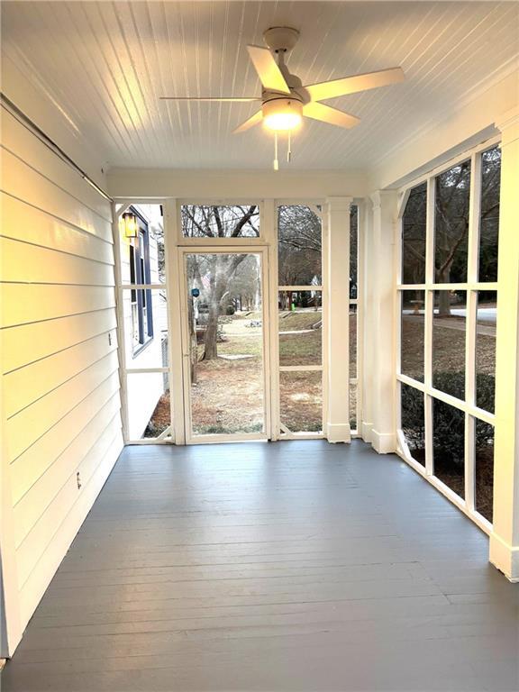 unfurnished sunroom with wood ceiling and ceiling fan