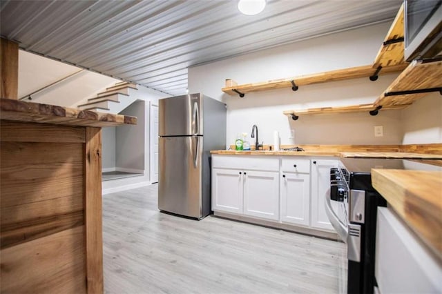 2125 Mccollum Church Rd, Lineville, AL 36266 - kitchen with open shelves, appliances with stainless steel finishes, butcher block counters, white cabinets, and light wood-style floors