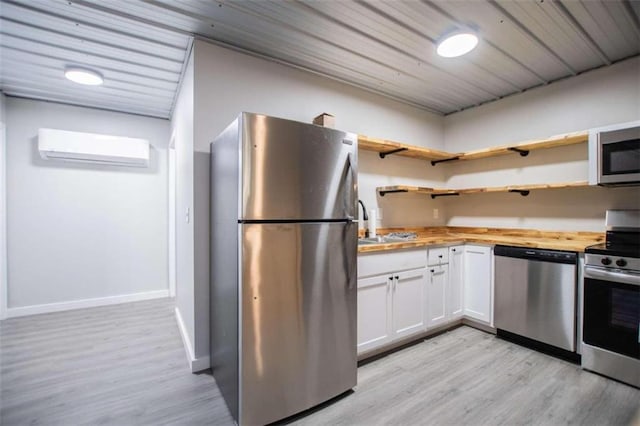 2125 Mccollum Church Rd, Lineville, AL 36266 - kitchen with appliances with stainless steel finishes, an AC wall unit, butcher block countertops, and light wood-style flooring
