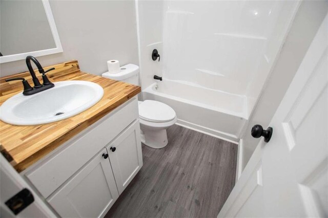 2125 Mccollum Church Rd, Lineville, AL 36266 - bathroom with toilet, vanity, wood finished floors, and bathing tub / shower combination