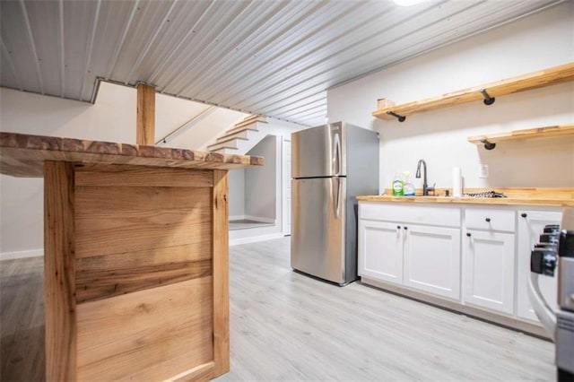2125 Mccollum Church Rd, Lineville, AL 36266 - kitchen with open shelves, freestanding refrigerator, white cabinetry, light wood-style flooring, and wood counters
