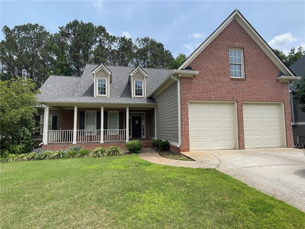 429 Bentleaf Dr, Dallas, GA 30132 - view of front facade with a porch, driveway, a front yard, brick siding, and an attached garage