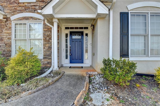 doorway to property with stone siding and stucco siding