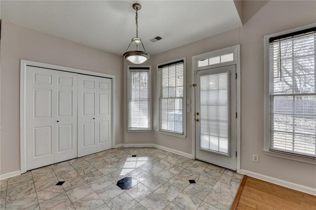 doorway with marble finish floor, visible vents, and baseboards