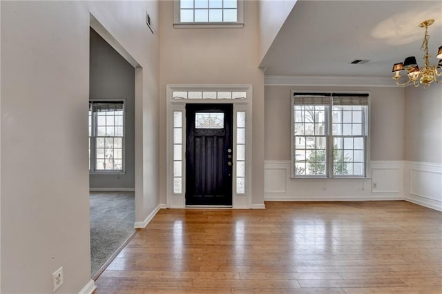 foyer featuring a wealth of natural light, a notable chandelier, and hardwood / wood-style floors