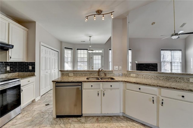 kitchen featuring stainless steel appliances, plenty of natural light, a sink, and white cabinets