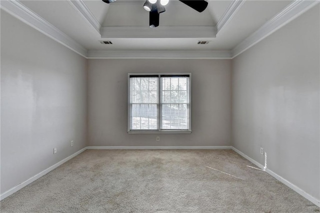 carpeted empty room featuring baseboards, a raised ceiling, visible vents, and crown molding