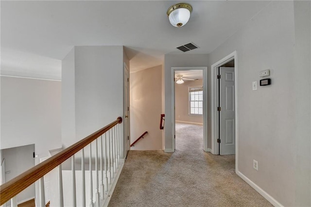 corridor featuring visible vents, carpet flooring, an upstairs landing, and baseboards