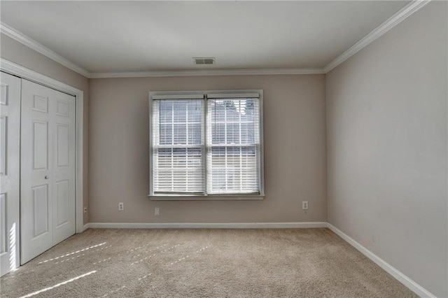 unfurnished bedroom with carpet floors, visible vents, ornamental molding, and baseboards