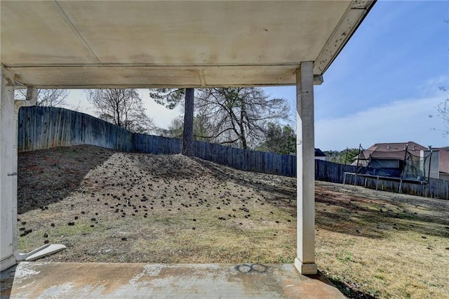 view of yard featuring a trampoline and a fenced backyard