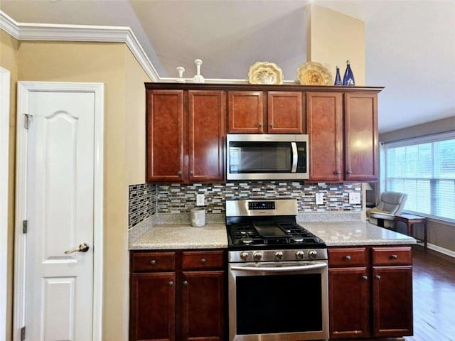 kitchen with appliances with stainless steel finishes, dark hardwood / wood-style floors, tasteful backsplash, and vaulted ceiling