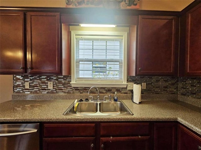 kitchen featuring stainless steel dishwasher, sink, and backsplash