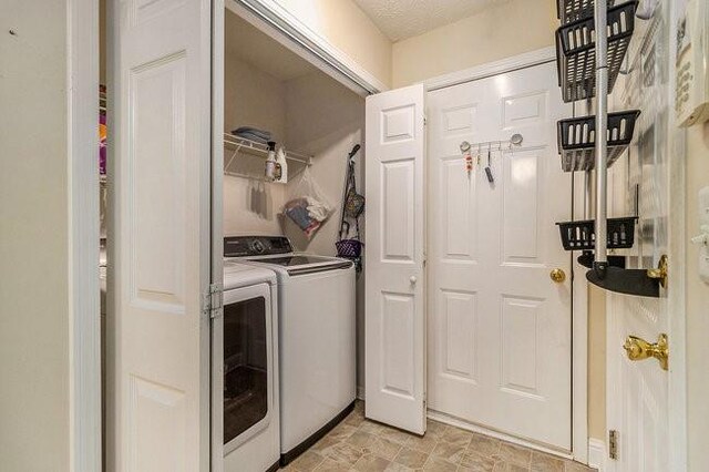 washroom featuring independent washer and dryer and a textured ceiling