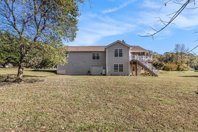 rear view of house featuring a yard and a deck