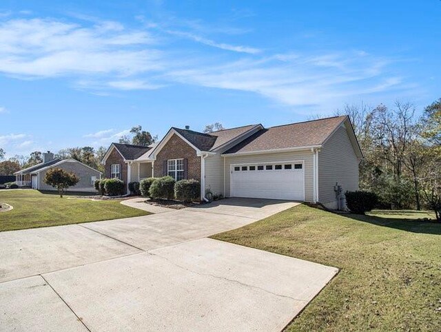 ranch-style home featuring a garage and a front yard