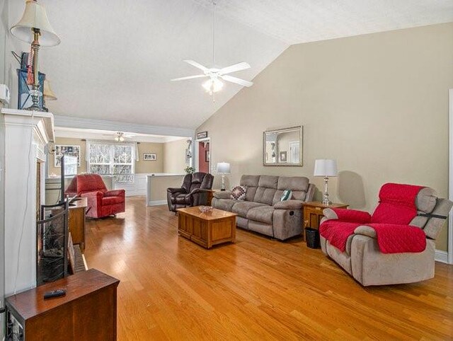 living room with hardwood / wood-style flooring, ceiling fan, and lofted ceiling