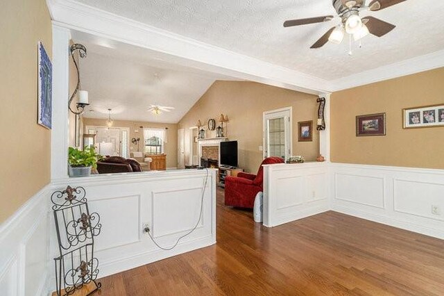 living room featuring a textured ceiling, dark hardwood / wood-style floors, ceiling fan, and lofted ceiling