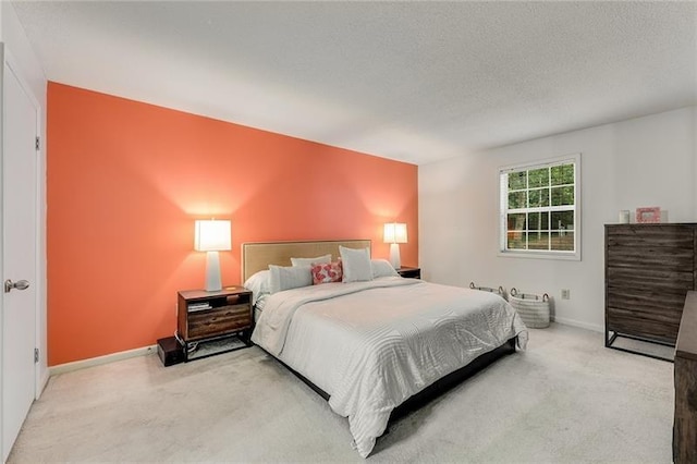 carpeted bedroom with a textured ceiling and baseboards