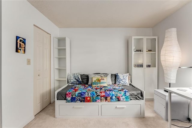 bedroom featuring a closet and light colored carpet